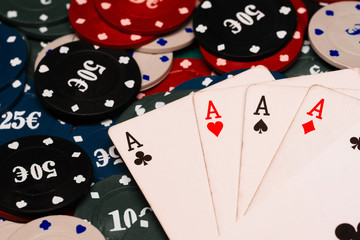 four of a kind of aces in poker on the background of the green table in the casino with chips