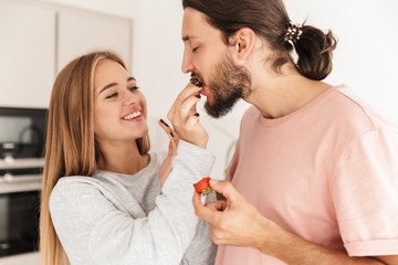 Happy young couple feeding each other with strawberries