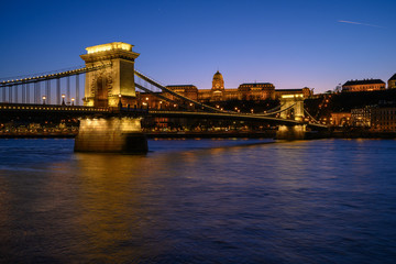 Fototapeta premium Budapest iconic Chain Bridge by night over the Danube River with the Royal Palace and the President's Palace