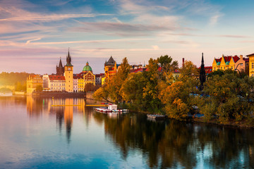 Autumn view to Charles bridge on Vltava river in Prague, Czech Republic. Autumn view to Charles Bridge, Prague old town and Vltava river. Czechia. Scenic autumn view of the Old Town with red foliage.