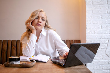 blonde girl in the office at the table with a laptop