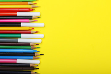 Multicolored markers and pencils at bright background	