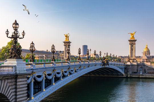 Pont Alexandre III bridge over river Seine in the sunny summer morning. Bridge decorated with ornate Art Nouveau lamps and sculptures. The Alexander III Bridge across Seine river in Paris, France.