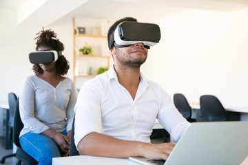 Focused African American user wearing VR glasses. Closeup shot of young tester experiencing virtual...
