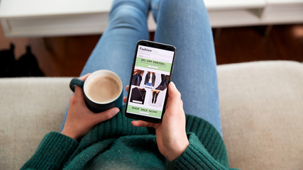 Close Up Of Woman Shopping For Clothes Online Using Mobile Phone App