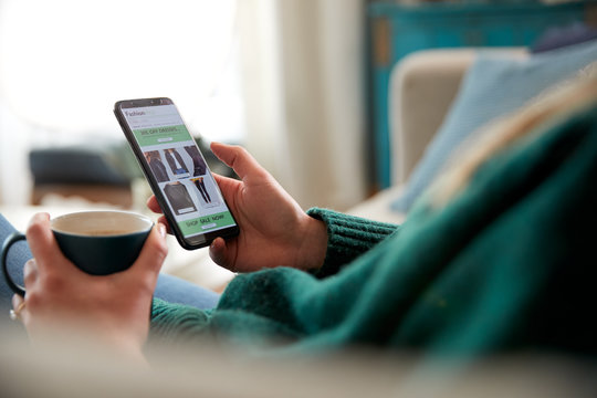 Close Up Of Woman Shopping For Clothes Online Using Mobile Phone App