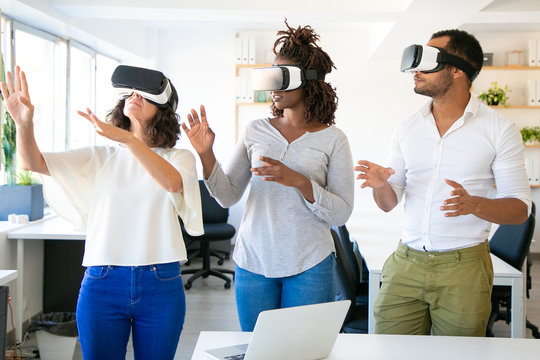 Three testers with VR headsets. Concentrated people standing in office with modern devices. Technology concept