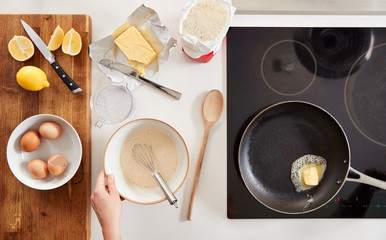 Overhead Shot Of Woman In Kitchen Mixing Ingredients For Pancakes Or Crepes For Pancake Day