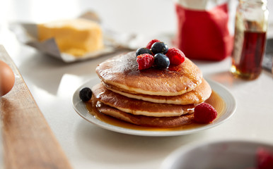 Stack Of Freshly Made Pancakes Or Crepes With Maple Syrup And Berries On Table For Pancake Day