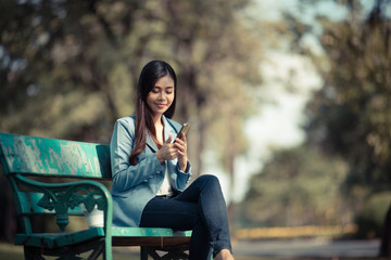 Asian business women are using smartphones to contact customers in the garden.