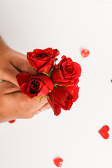 Red rose in hands of young man