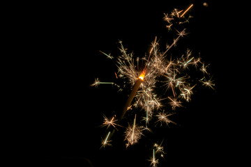Fototapeta premium Sparklers burn in the dark, creating a festive mood.