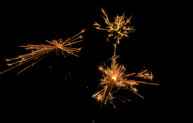 Sparklers burn in the dark, creating a festive mood.