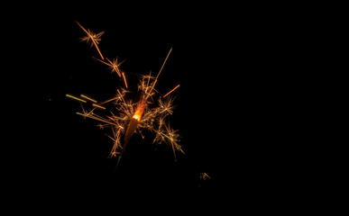 Sparklers burn in the dark, creating a festive mood.