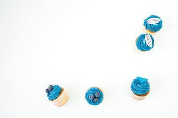 Blueberry muffins with cream isolated on white background. Flat lay