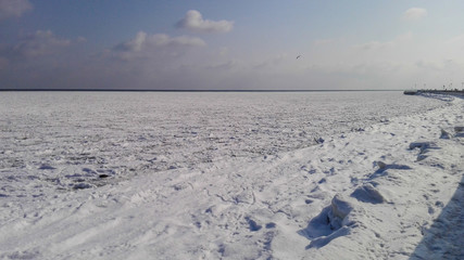 winter landscape with frozen sea and blue sky