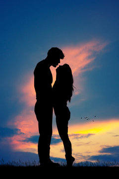 couple kissing silhouette at sunset