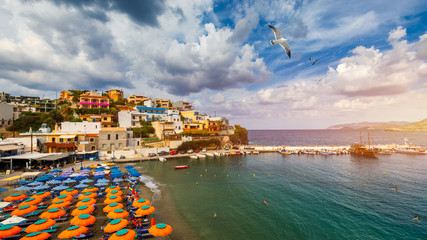 Panorama of Harbour with vessels, boats, beach and lighthouse in Bali at sunrise, Rethymno, Crete, Greece. Famous summer resort in Bali village, near Rethimno, Crete, Greece.