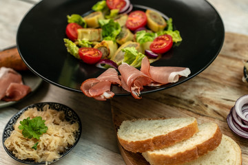 delicious German traditional specialties, Tyrolean ham, maultaschen, sauerkraut, fresh slices of baguette