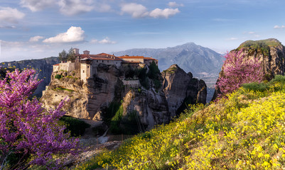 Fototapeta na wymiar Scenic image of spring Landscape Monastery Meteora Greece. Stunning spring panoramic landscape. View at mountains and blossoming trees during sunrise. Wonderful nature scene.
