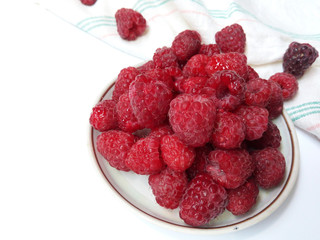 Raspberries on the plate  juicy , vegan , tasty berry  on white background , raw, fresh, natural, summer, food photo with a retro towel