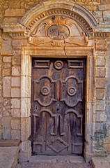 An old decorated wooden door with surrounding decorative classical stonework in Provence South of France