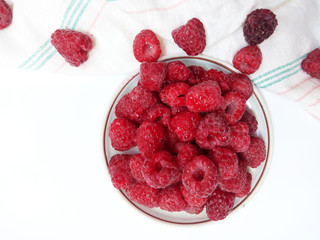 Raspberries on the plate  juicy , vegan , tasty berry  on white background , raw, fresh, natural, summer, food photo with a retro towel