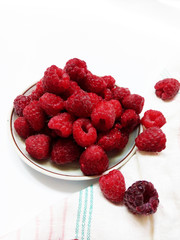 Raspberries on the plate  juicy , vegan , tasty berry  on white background , raw, fresh, natural, summer, food photo with a retro towel