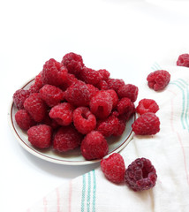 Raspberries on the plate  juicy , vegan , tasty berry  on white background , raw, fresh, natural, summer, food photo with a retro towel