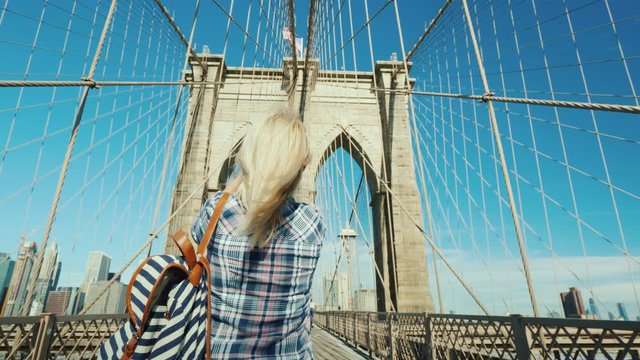 A woman takes pictures of herself on the famous Brooklyn Bridge - one of the main attractions of New York
