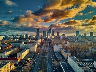 Beautiful panoramic aerial drone view to the Сenter of modern Warsaw city with silhouettes of skyscrapers in in the rays of the setting winter January sun - amazing sunset, Poland
