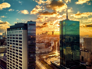 Fototapeta na wymiar Beautiful panoramic aerial drone view to the Сenter of modern Warsaw city with silhouettes of skyscrapers in in the rays of the setting winter January sun - amazing sunset, Poland