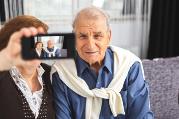 Senior couple makes selfie using a smartphone