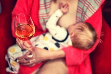 Poster Breastfeeding infant and mother with alcohol drink © Jaroslav Moravcik