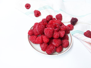 Raspberries on the plate  juicy , vegan , tasty berry  on white background , raw, fresh, natural, summer, food photo with a retro towel