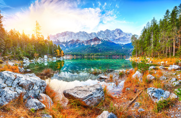 Faboulus autumn landscape of Eibsee Lake in front of Zugspitze summit under sunlight