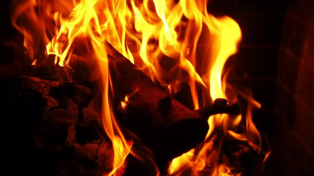 Slow motion video of cosy fireplace with reddish flame burning during winter holidays