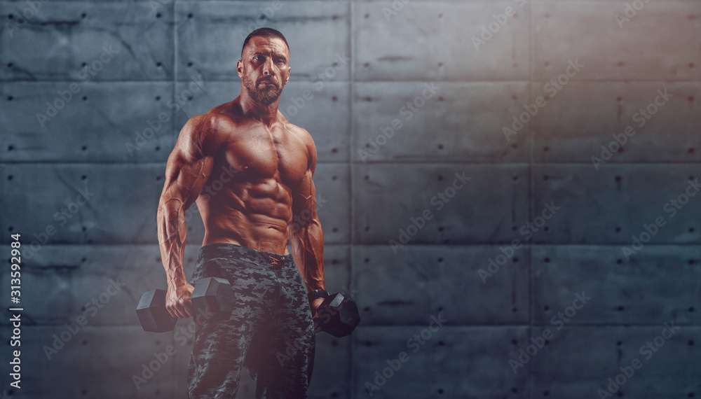 Wall mural handsome athletic muscular men exercising with weights. copy space