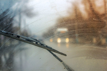 Windshield wipers from inside of car, season rain. the front and background are blurred with a bokeh effect - obrazy, fototapety, plakaty