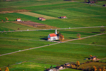 Aerial view of famous white St. Coloman pilgrimage church in autumn