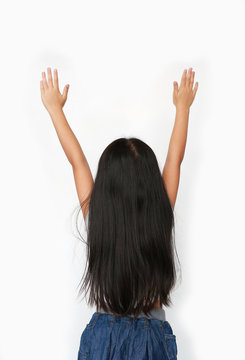Little Asian child girl raising hands up isolated over white background. Rear view.