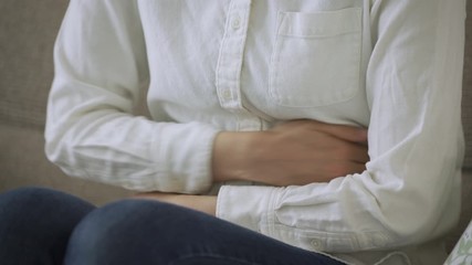 お腹をさする若い女性