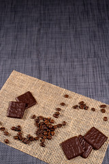 coffee beans and chocolate on burlap background, vertical shot, space for text