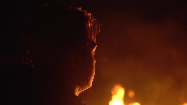 Young teenager looks at a big fire