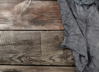 black textile kitchen towel on a wooden background from old gray boards