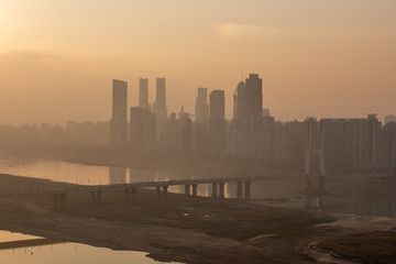 Heavy fog on the river and forest in calm morning weather. View of the residential buildings through the haze.morning urban landscape. Foggy City.Houses Protruding Through Fog.