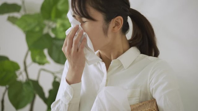鼻をかむ若い女性