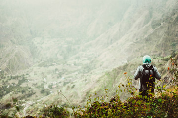 Fototapeta na wymiar Man tourist with backpack enjoying valley rural landscape on hike path at Santo Antao Island, Cape Verde