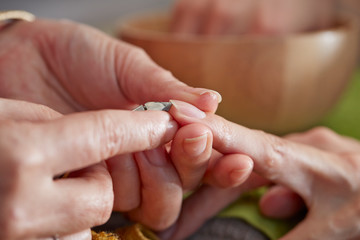 Nail care service at salon, removing cuticle with nail nipper 