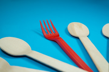 Single red plastic fork amongst wooden spoons